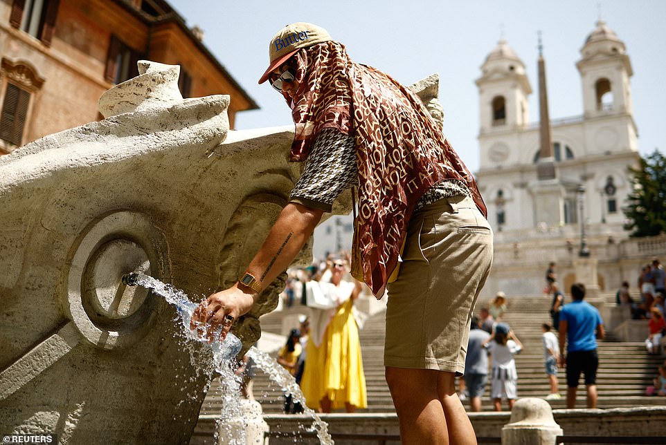 A man whose head is covered in a scarf to shield him from the searing sun fills a bottle of water at the Fontana della Barcaccia at the Spanish Steps in Rome during a heat wave across Italy on Monday