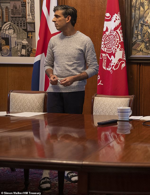 Mr Sunak wearing a paid of £95 plastic sliders while preparing the Budget in 2021