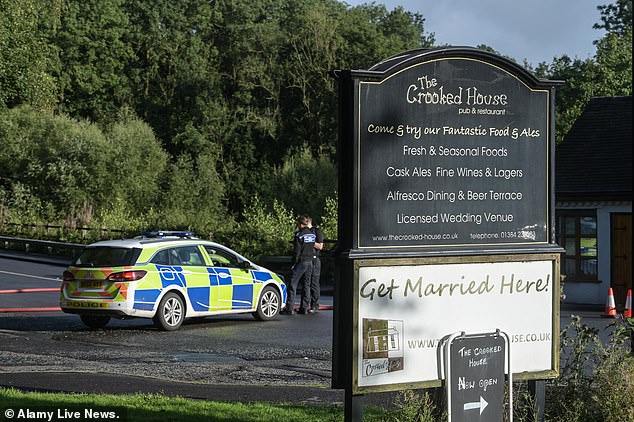 Police are pictured at The Crooked House pub today as they investigate the fire hat erupted at the building late last night