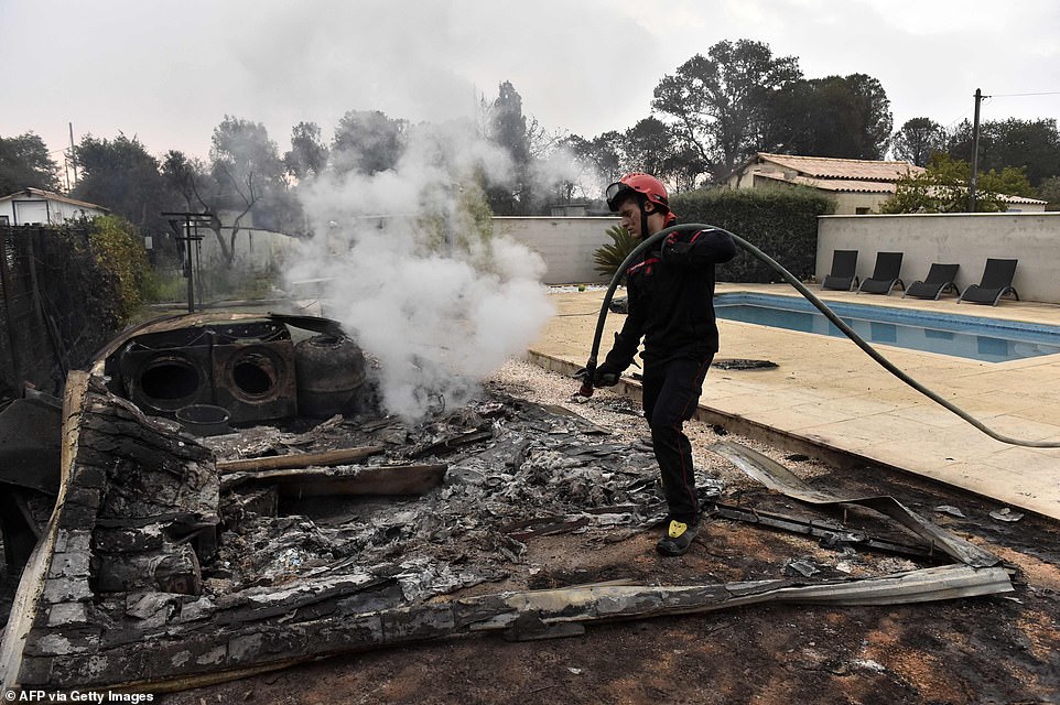 A firefighter puts out fires after the blaze that ravaged the commune of Saint-Andre on Tuesday