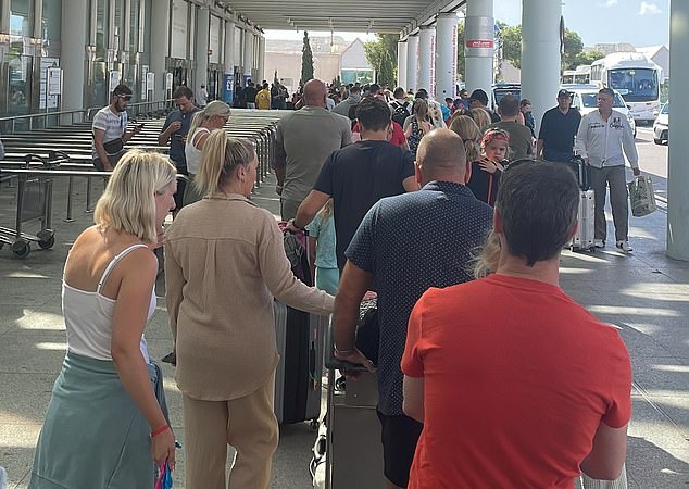 A long queue of passengers queueing outside the terminal in Mallorca following today's air traffic control outage
