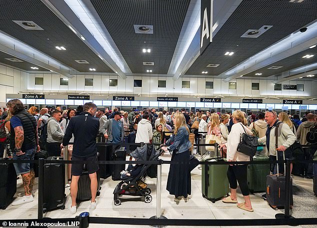 Passengers queue for check-in at Manchester Airport's Terminal Two this morning