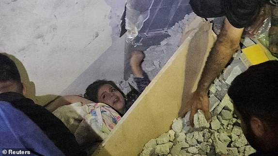 Palestinians work to rescue a boy trapped in the rubble following an Israeli strike on a house in Jabalia in the northern Gaza Strip, October 19, 2023. REUTERS/Anas al-Shareef