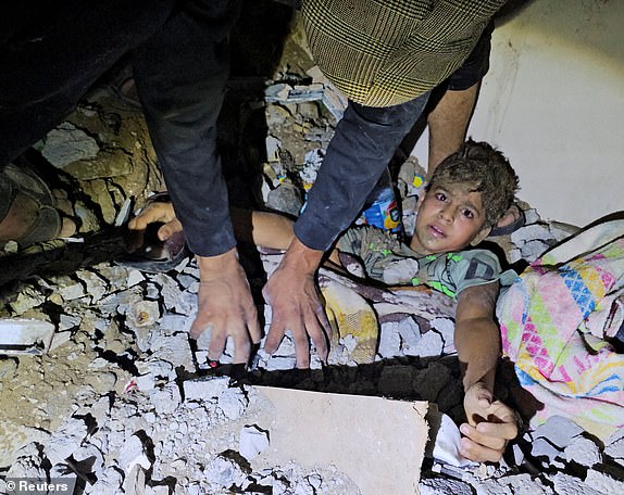 Palestinians work to rescue a boy trapped in the rubble following an Israeli strike on a house in Jabalia in the northern Gaza Strip, October 19, 2023. REUTERS/Anas al-Shareef