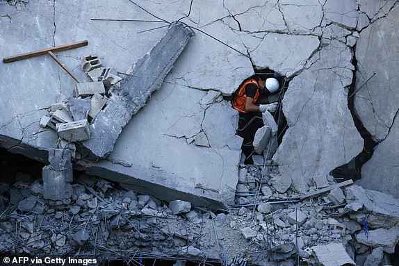 EDITORS NOTE: Graphic content / Members of the Palestinian civil defence look for survivors in the rubble of a building hit during Israeli bombardment in Khan Yunis on the southern Gaza Strip on October 19, 2023. Thousands of people, both Israeli and Palestinians have died since October 7, 2023, after Palestinian Hamas militants based in the Gaza Strip, entered southern Israel in a surprise attack leading Israel to declare war on Hamas in Gaza on October 8. (Photo by MAHMUD HAMS / AFP) (Photo by MAHMUD HAMS/AFP via Getty Images)