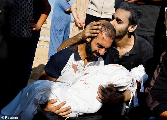 The father of Alma Al Majayda, 3, killed in Israeli strikes, embraces her body during her funeral, amid the ongoing conflict between Israel and Palestinian Islamist group Hamas, in Khan Younis in the southern Gaza Strip, October 19, 2023. REUTERS/Mohammed Salem TPX IMAGES OF THE DAY