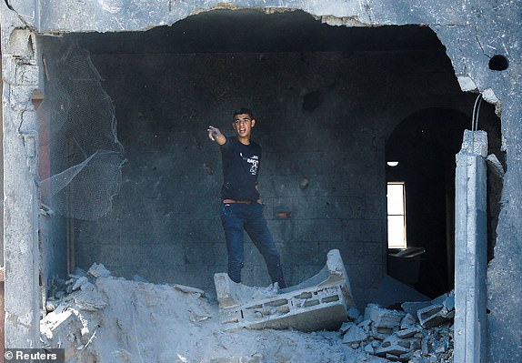 A man gestures at the site where a girl was killed in Israeli strikes on a house in Khan Younis,amid the ongoing conflict between Israel and Palestinian Islamist group Hamas, in the southern Gaza Strip, October 19, 2023. REUTERS/Ibraheem Abu Mustafa