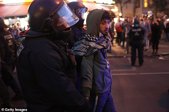 BERLIN, GERMANY - OCTOBER 18: Riot police detain a young man at a gathering of pro-Palestinian demonstrators on Sonnenallee in Arab-heavy Neukoelln district on October 18, 2023 in Berlin, Germany. Several hundred protesters defied a ban on the protest to gather and shout "Free, free Palestine!" and "Allahu Akbar." The current conflict between Hamas and Israel is continuing to claim lives daily, especially since yesterday's explosion at a hospital in Gaza that reportedly left hundreds dead. An Israeli invasion of Gaza is possibly imminent. (Photo by Sean Gallup/Getty Images)
