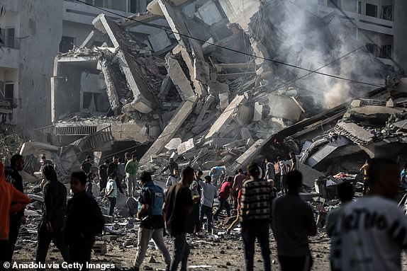 GAZA CITY, GAZA - OCTOBER 19: Palestinians are seen near debris of destroyed buildings after Israeli airstrikes at al-Zahra neighborhood in Gaza Strip on October 19, 2023. (Photo by Ali Jadallah/Anadolu via Getty Images)
