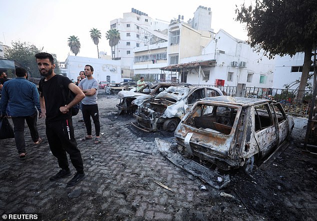 People inspect the area of Al-Ahli hospital where hundreds of Palestinians were killed in a blast that Israeli and Palestinian officials blamed on each other, and where Palestinians who fled their homes were sheltering amid the ongoing conflict with Israel, in Gaza City, October 18, 2023