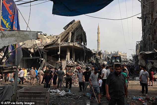 Palestinians examine destroyed buildings in Gaza City on Saturday. The Israel Defence Forces (IDF) is sending ground troops and armoured vehicles into the occupied territory
