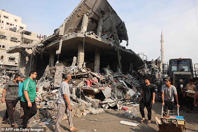 People gather in the streets at the Al-Shatee refugee camp in northern Gaza, which was subjected to heavy bombardment by Israel overnight into Saturday