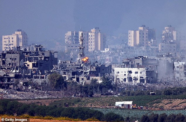 A missile strikes a minaret in Gaza on Saturday - as Israel's deadly overnight bombing of the enclave continued into the daytime
