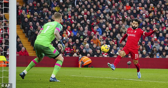 Liverpool's Mohamed Salah, right, attempts a shot on goal during the English Premier League soccer match between Liverpool and Brentford at Anfield stadium in Liverpool, England, Sunday, Nov. 12, 2023. (AP Photo/Jon Super)