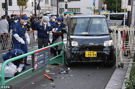 epa10977734 Japanese policemen investigate the scene after a driver crashed a car into a police barricade near the Israel Embassy, in Tokyo, Japan, 16 November 2023. Police arrested the driver of the car, a man in his 50's, who was lightly injured in the crash.  EPA/KIMIMASA MAYAMA