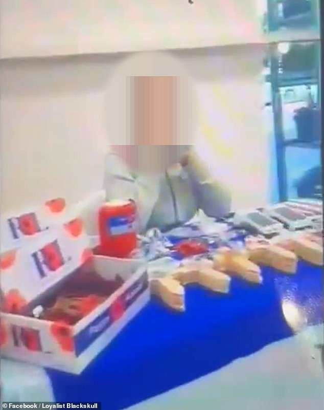 The irate woman hits out at the pensioner behind the stall - saying it is 'not acceptable' to the Catholic community for her to be selling the remembrance material