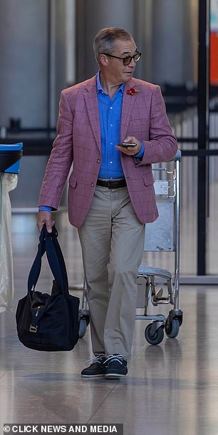 On my way: Nigel flashed a beaming smile as he strolled through the terminal