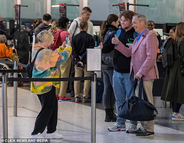 Smile! Nigel was pictured snapping a picture with fans in the airport