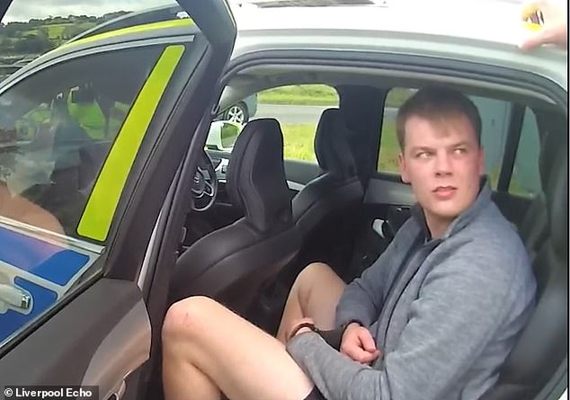 Barry - one of the organisers of the shooting - in the back of a police car wearing cuffs