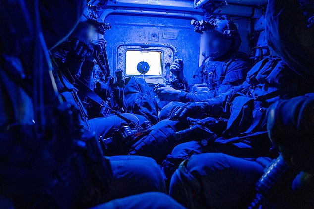 Israeli soldiers inside a military vehicle are seen on their way to storm the Al Shifa hospital in this picture released by the IDF