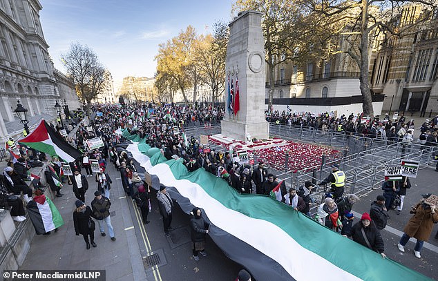 Pro-Palestine demonstrators unfurled a giant Palestinian flag as they passed The Cenotaph decorated with poppies, in Whitehall yesterday