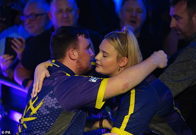 Littler hugs girlfriend Eloise after his sensational victory at London's Alexandra Palace on Monday