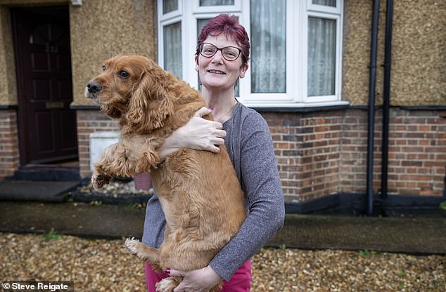 Mrs Milburn pictured with dog Lucy outside her home in Hersham, Surrey