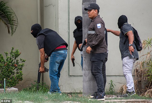Police officers carry out an operation at the headquarters of TC television station where armed, hooded men entered and subdued staff during a live broadcast, in Guayaquil, Ecuador, on Tuesday