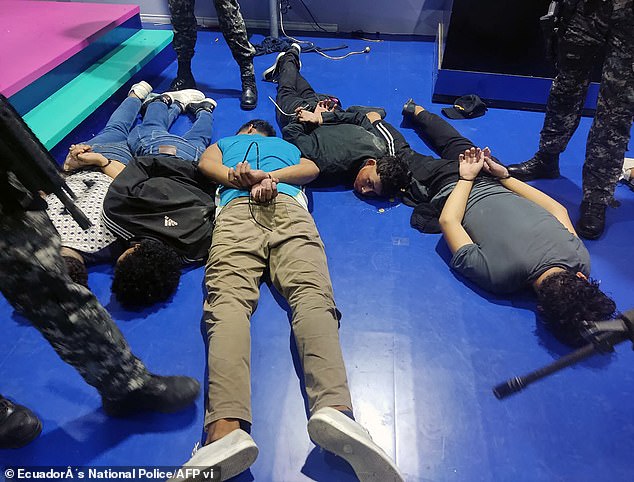 Pictured: Suspects detained by police officers inside the studio of public television station TC who took hostage several journalists and staff members on Tuesday