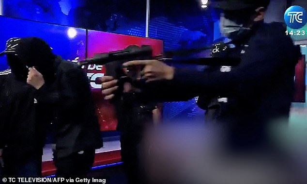 Video grab from live footage of Ecuadorean TC Television showing armed men wearing balaclavas bursting into the studio of public television station TC in drug violence-torn port city of Guayaquil on Tuesday