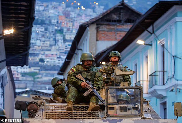 Soldiers in an armoured vehicle patrol the city of Quito's historic centre following an outbreak of violence on Tuesday