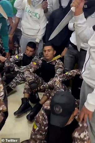 Terrifying footage shows gang members wielding machetes next to prison guards they are holding hostage