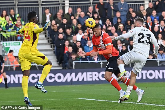 Luton Town's English striker #09 Carlton Morris (C) heads their first goal past Manchester United's Cameroonian goalkeeper #24 Andre Onana (L) during the English Premier League football match between Luton Town and Manchester United at Kenilworth Road in Luton, north of London on February 18, 2024. (Photo by Glyn KIRK / AFP) / RESTRICTED TO EDITORIAL USE. No use with unauthorized audio, video, data, fixture lists, club/league logos or 'live' services. Online in-match use limited to 120 images. An additional 40 images may be used in extra time. No video emulation. Social media in-match use limited to 120 images. An additional 40 images may be used in extra time. No use in betting publications, games or single club/league/player publications. /  (Photo by GLYN KIRK/AFP via Getty Images)