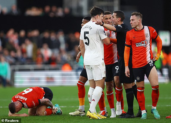 Soccer Football - Premier League - Luton Town v Manchester United - Kenilworth Road, Luton, Britain - February 18, 2024 Referee David Coote remonstrates to Manchester United's Harry Maguire REUTERS/Hannah Mckay NO USE WITH UNAUTHORIZED AUDIO, VIDEO, DATA, FIXTURE LISTS, CLUB/LEAGUE LOGOS OR 'LIVE' SERVICES. ONLINE IN-MATCH USE LIMITED TO 45 IMAGES, NO VIDEO EMULATION. NO USE IN BETTING, GAMES OR SINGLE CLUB/LEAGUE/PLAYER PUBLICATIONS.