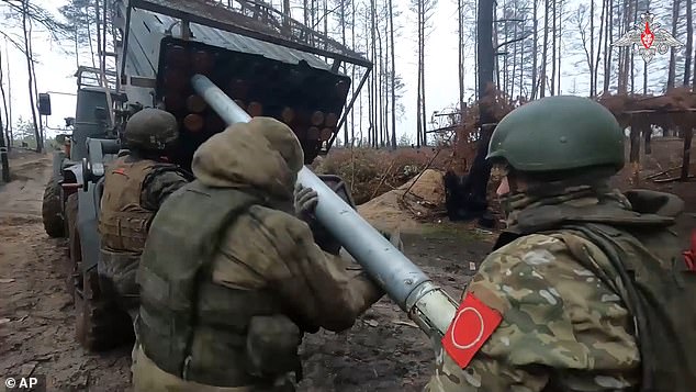 Russian soldiers load a rocket into a Grad rocket launcher on a mission at an undisclosed location in Ukraine