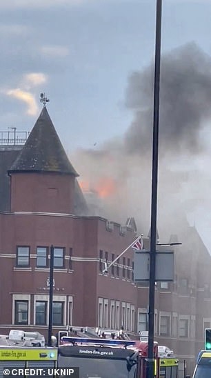 Firefighters aim water at the flames