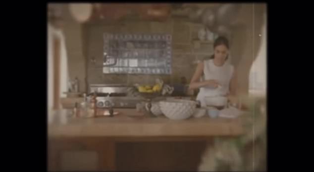 It then fades to reveal Meghan cooking in a stunning kitchen, with copper pans hanging over her head as she whisks