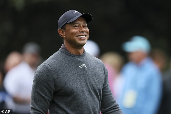 Tiger Woods reacts as he talks with fellow golfers as they walk down the second fairway after their tee shots during a practice round for the Masters golf tournament at Augusta National Golf Club in Augusta, Ga., Tuesday, April 9, 2024. (Jason Getz/Atlanta Journal-Constitution via AP)