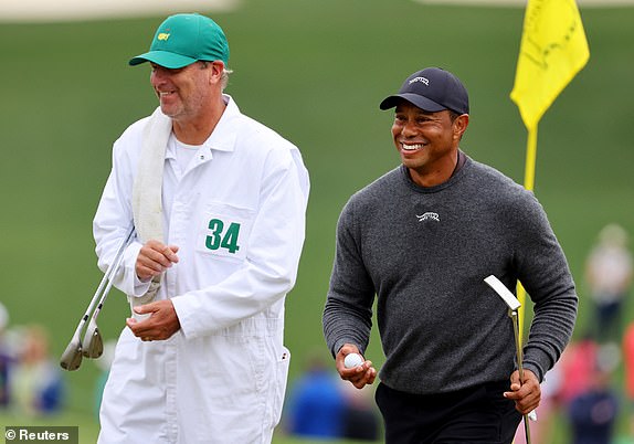 Golf - The Masters - Augusta National Golf Club, Augusta, Georgia, U.S. - April 9, 2024 Tiger Woods of the U.S. and his caddie on the green on the 9th hole during a practice round REUTERS/Mike Blake